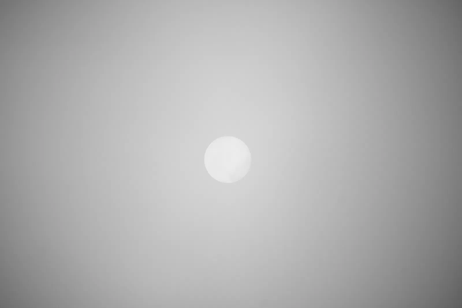 Sun barely visible through thick fog
