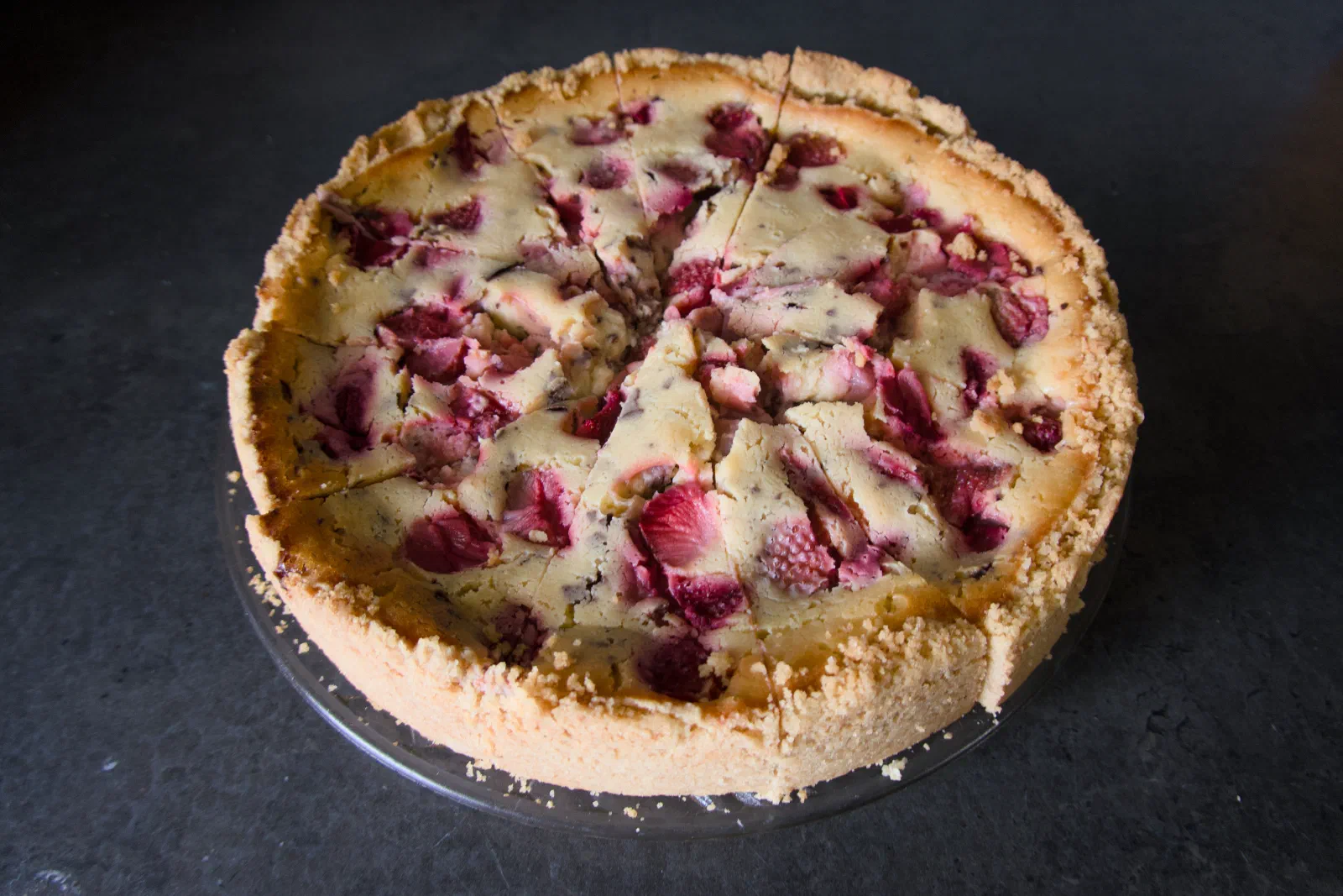 Strawberry cheesecake on a dark surface, cut into slices