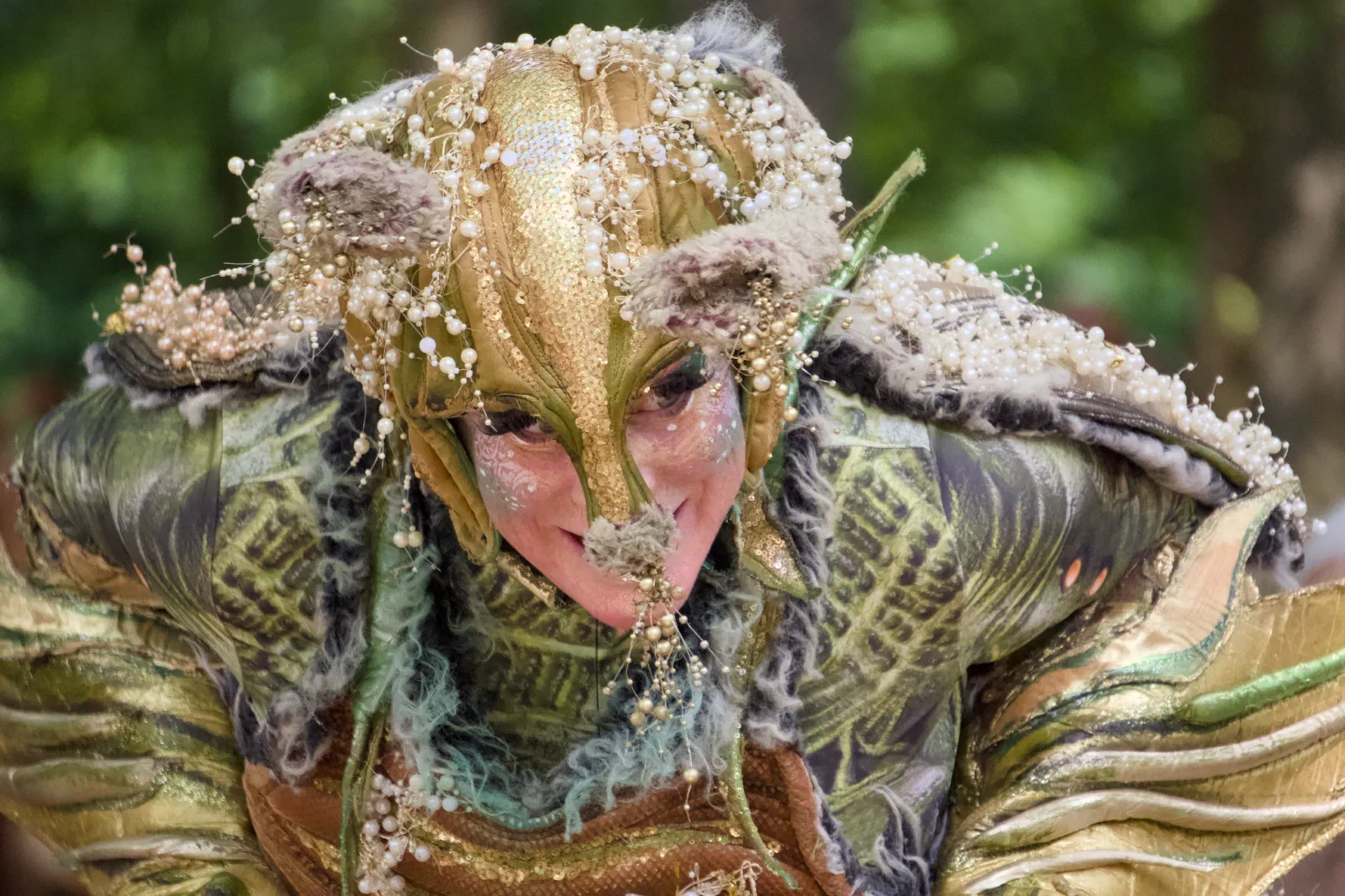 A performer in a golden fantasy creature costume