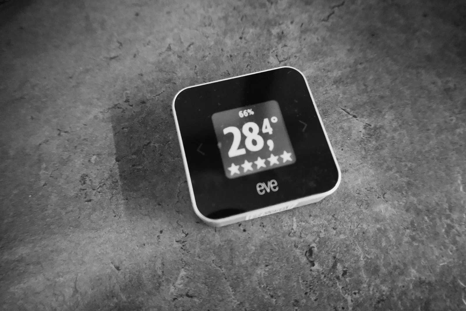 Black and white photo of an Eve room sensor reading 28.4 degrees
