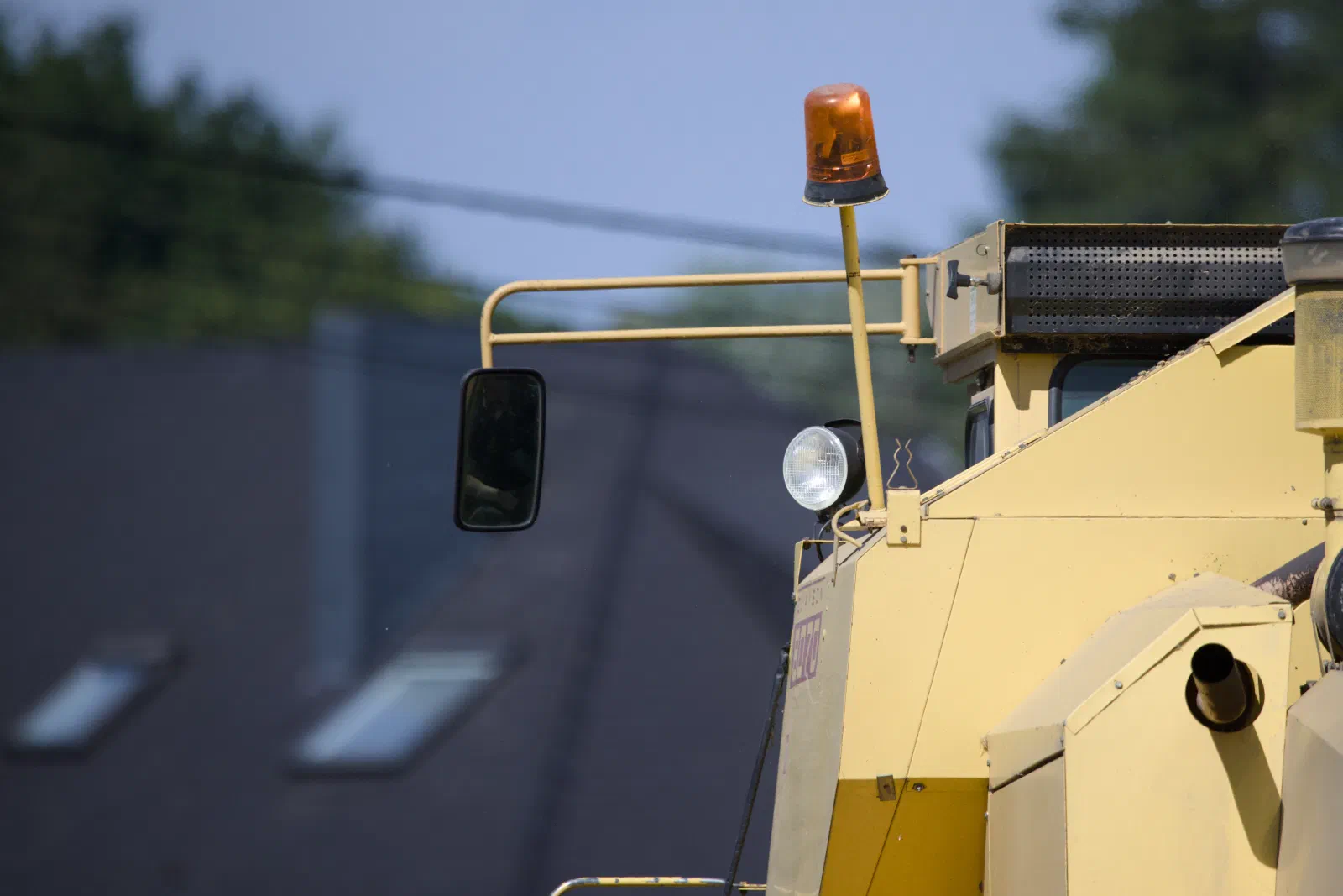 Mirror and beacon of an old yellow combine harvester