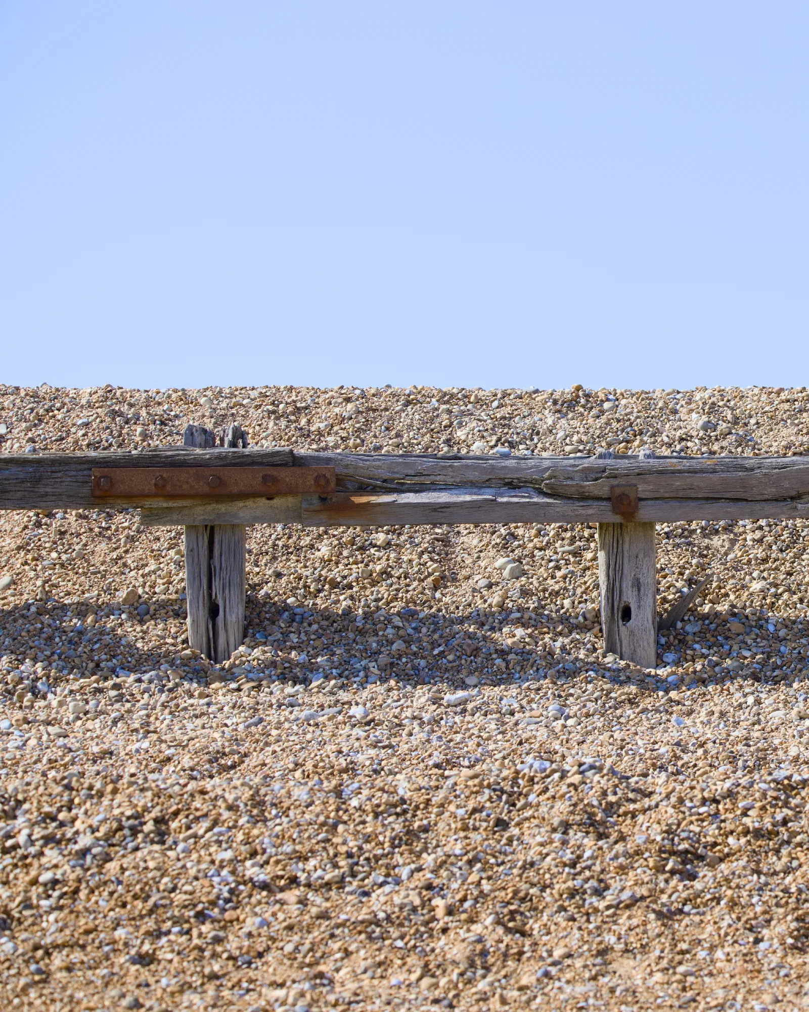 Weathered wooden groyne on a shingle beach
