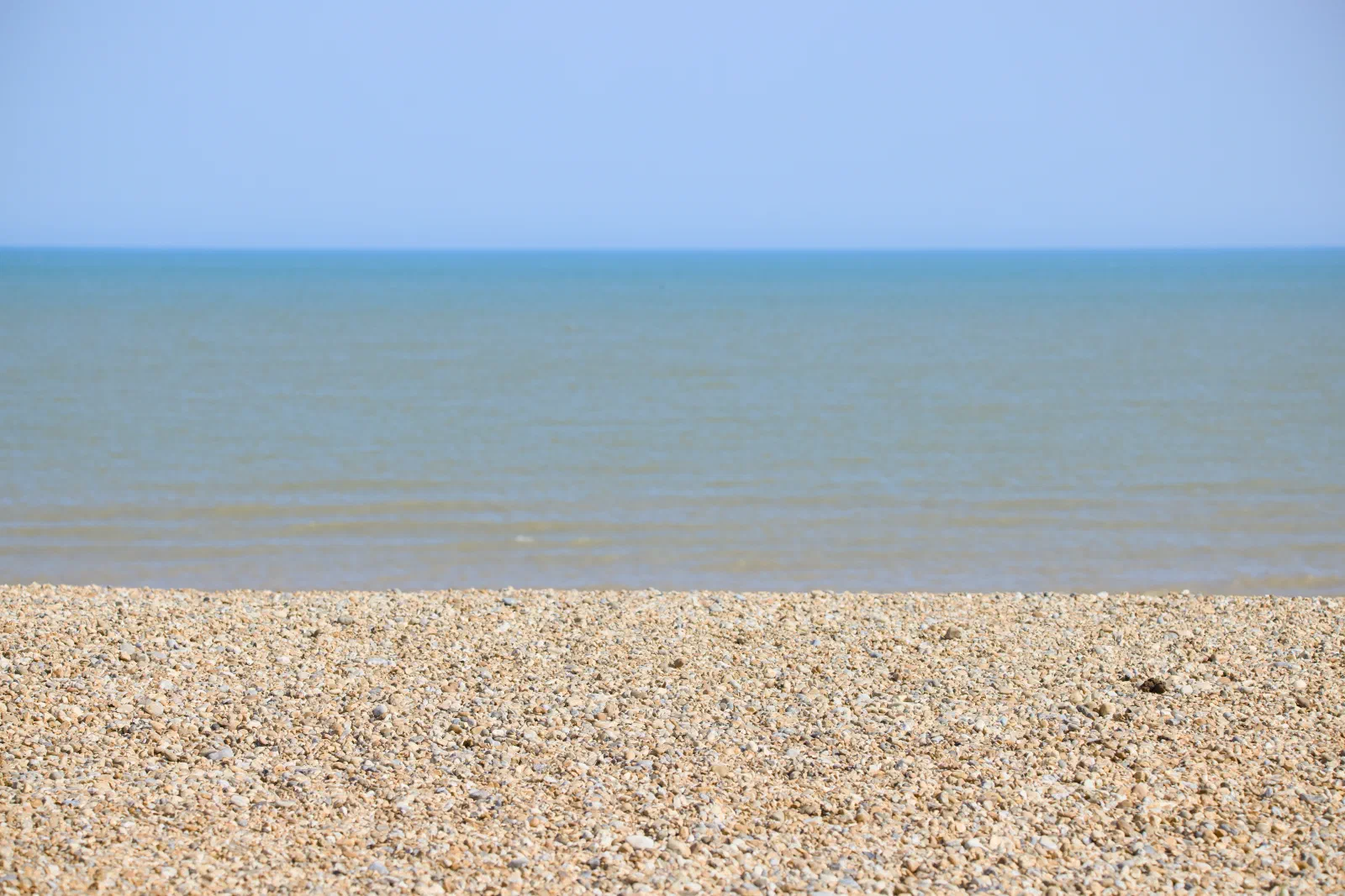 Shingle beach and the sea under a clear sky