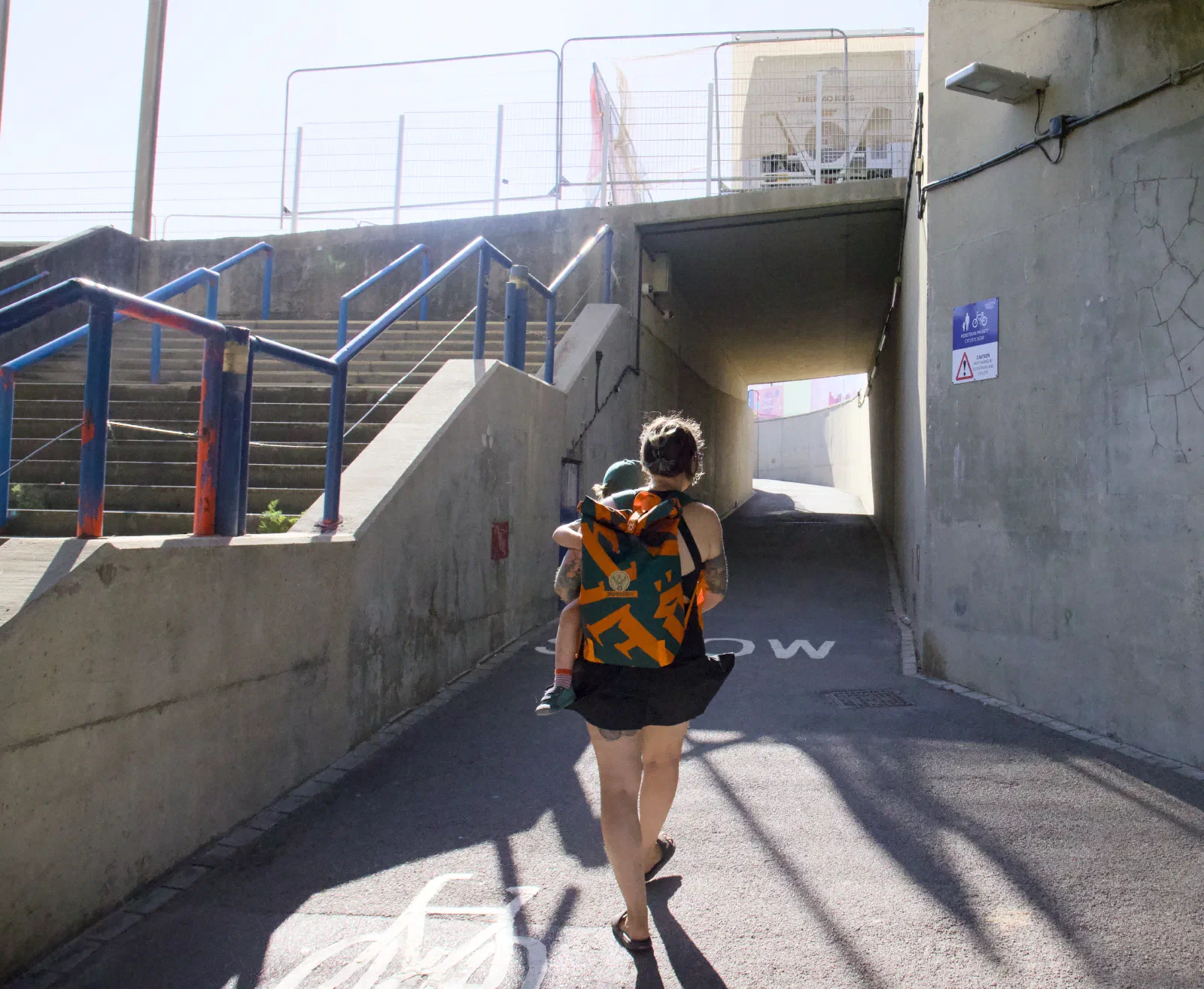 Nadine carrying Kellin through the underpass towards the seafront