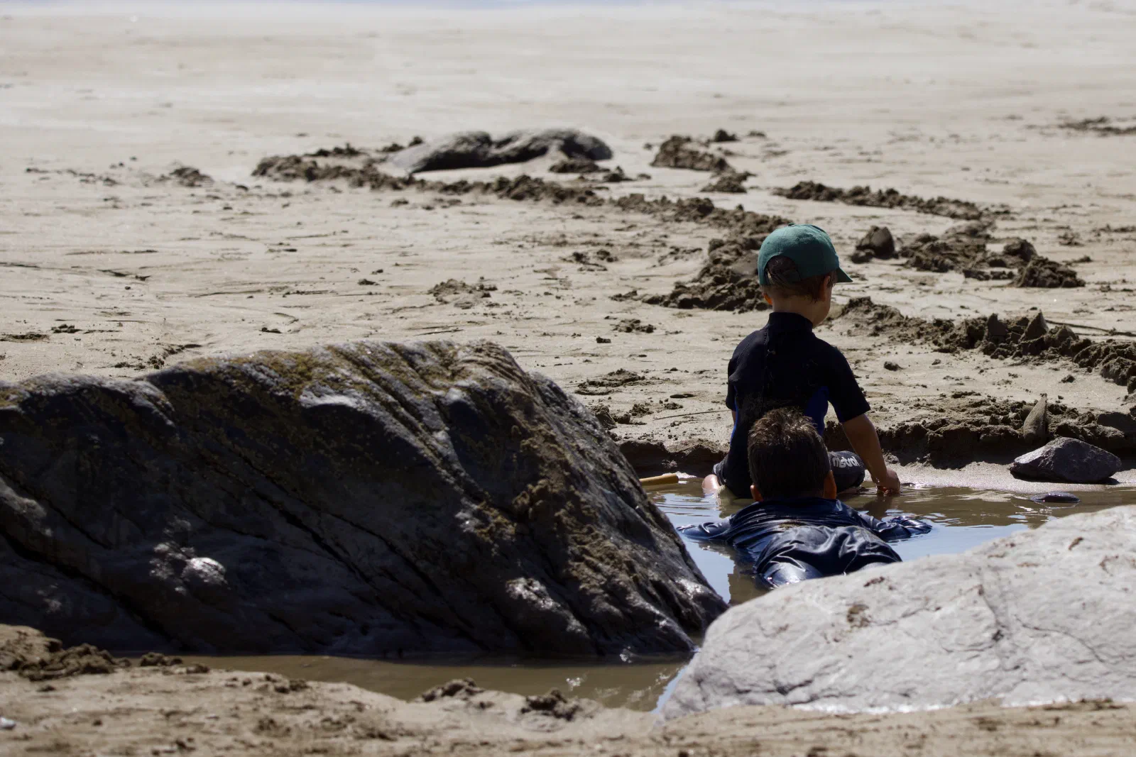 The boys playing in a tide pool between the rocks