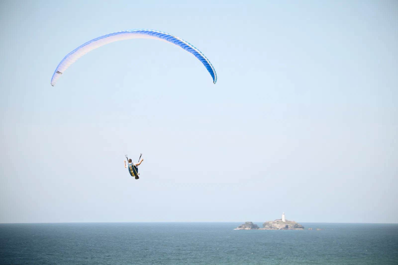 Paraglider over the sea, Godrevy lighthouse in the distance