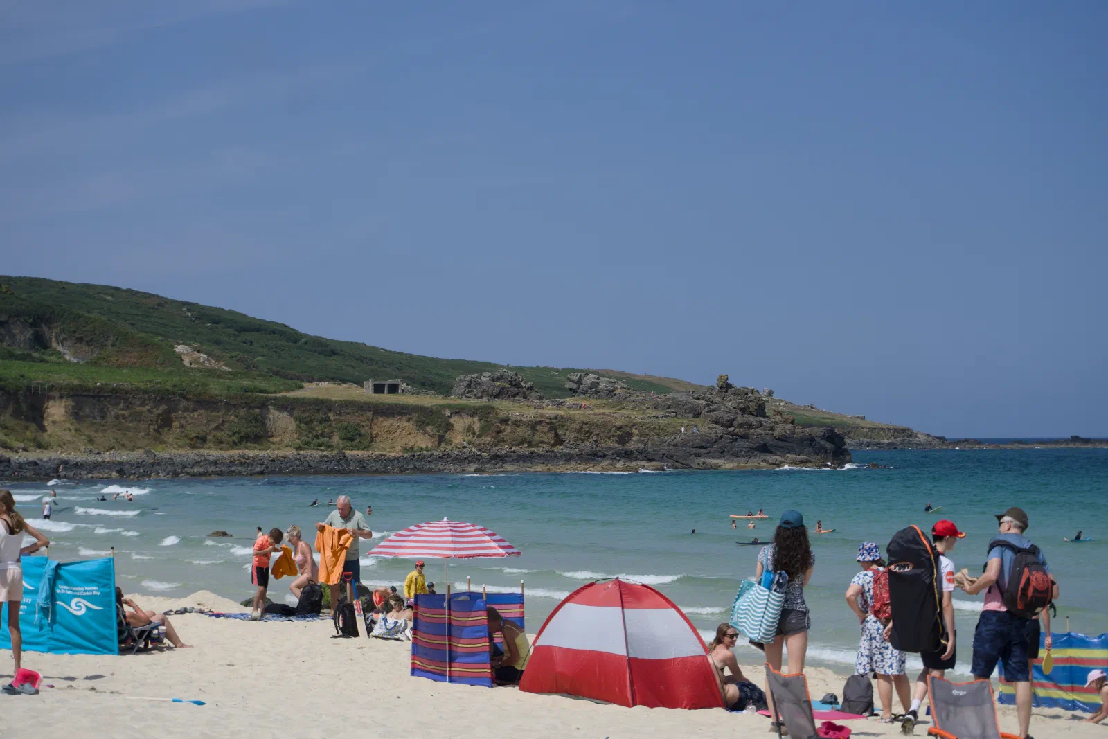 Busy beach in St Ives with a green headland behind