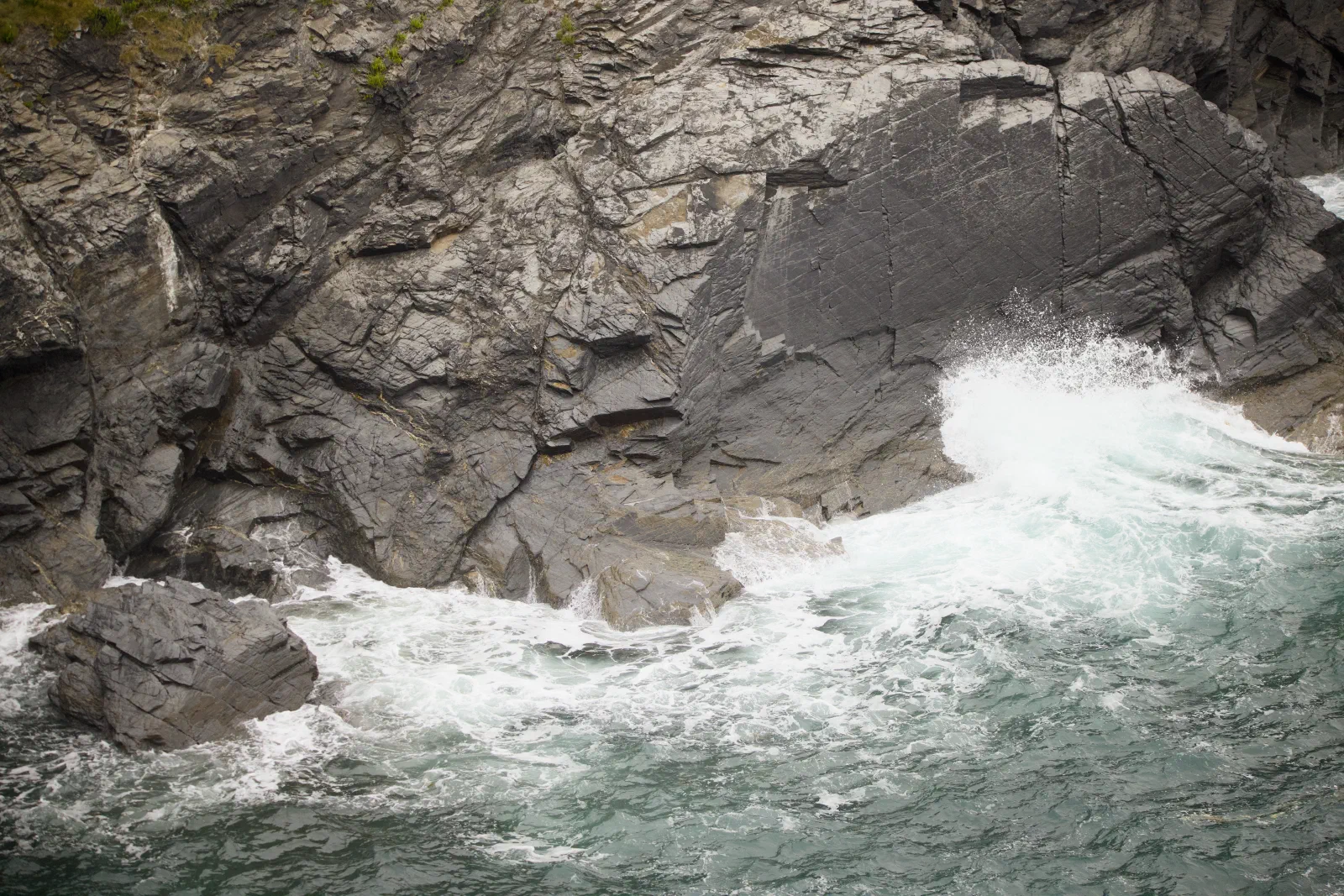 Wave breaking on the rocks below the cliff