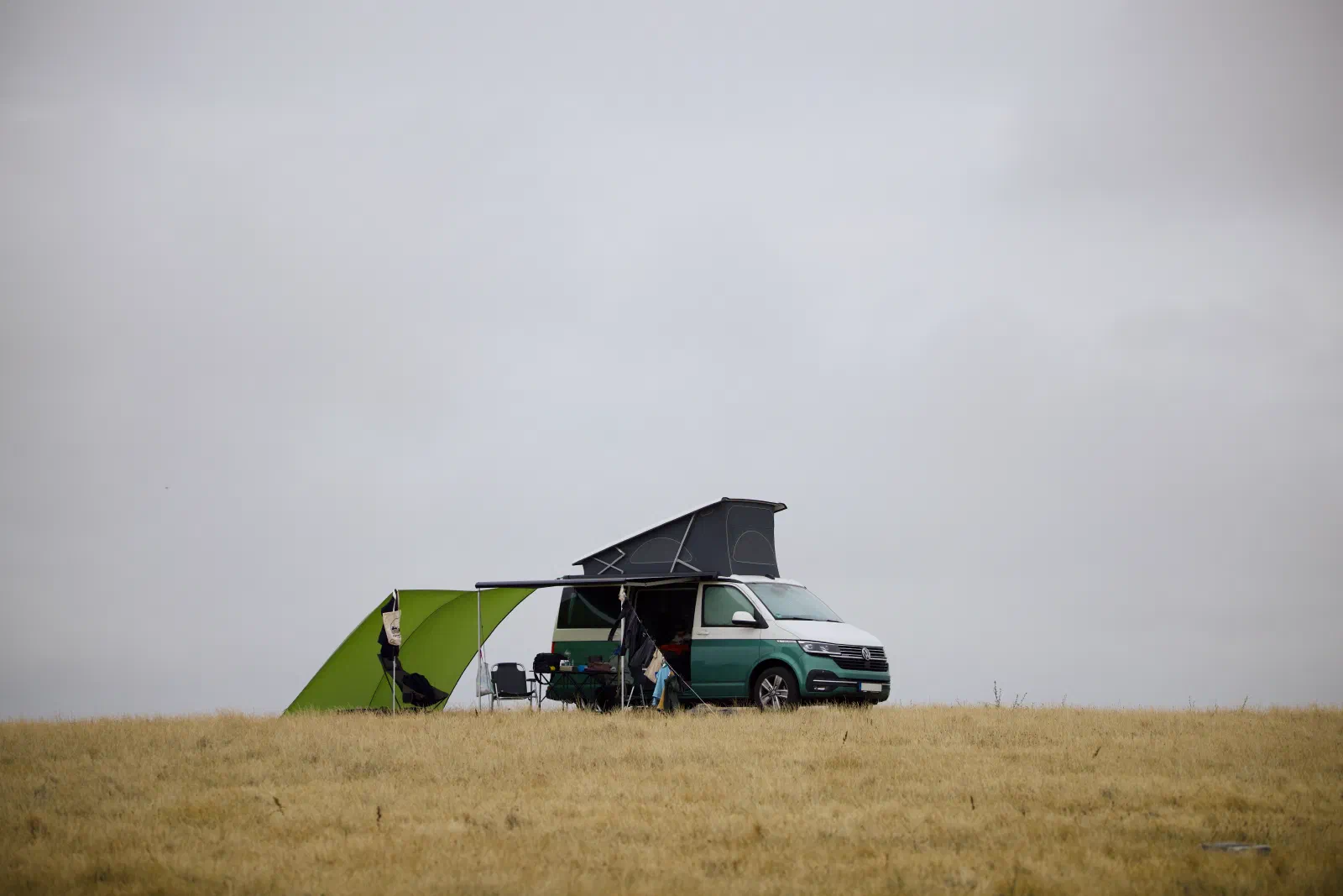 The California with the roof up and a green windbreak on the cliff-top field