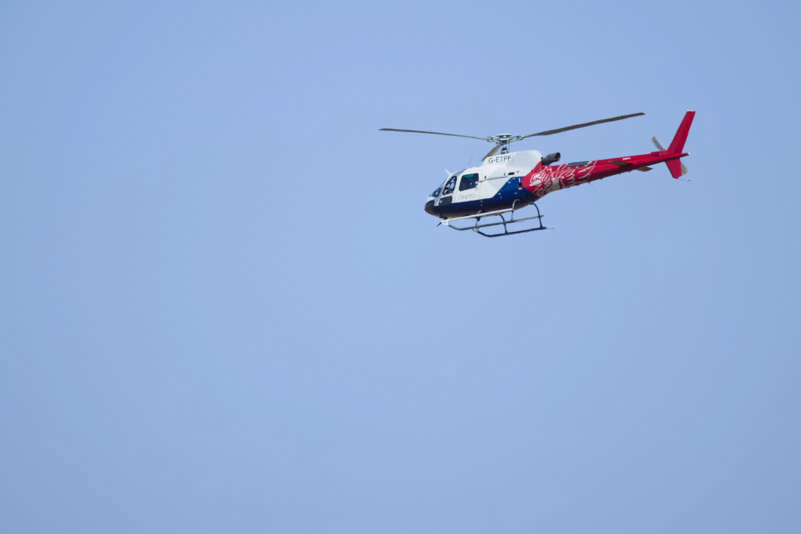 QinetiQ helicopter in flight against a blue sky