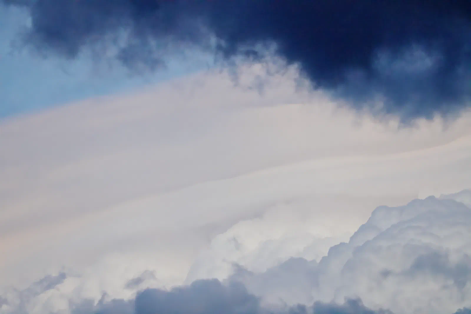 Dark cloud band over layered clouds