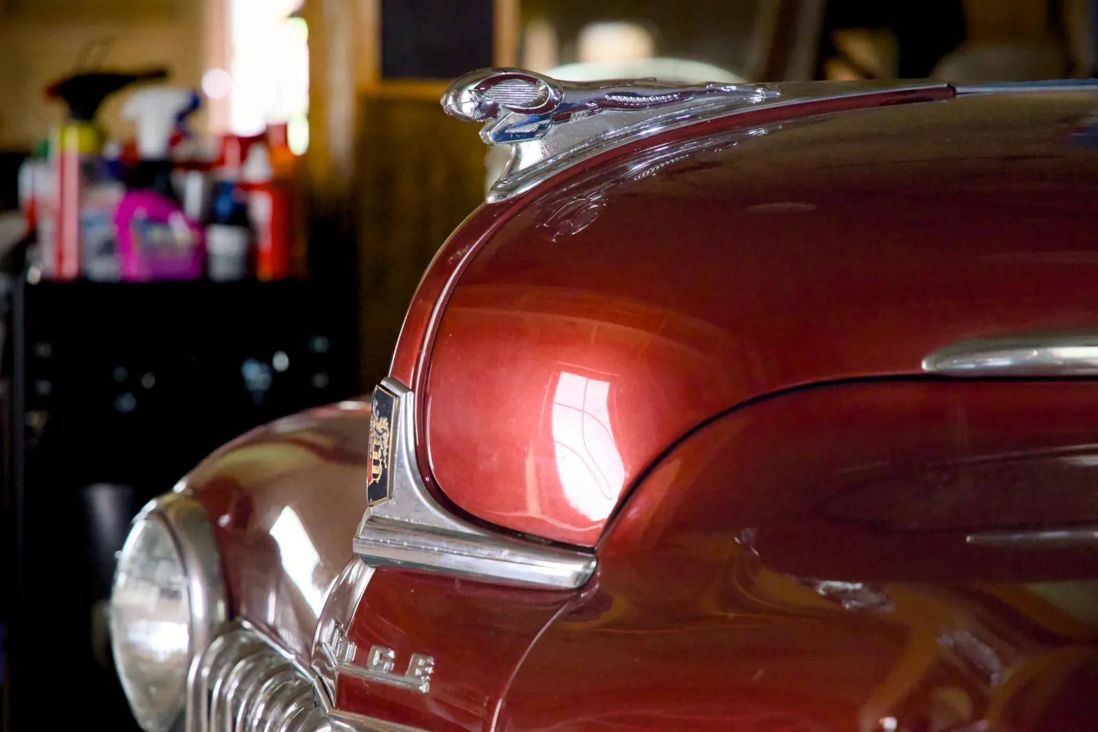 Hood ornament and grille of a maroon 1948 Dodge Coupe