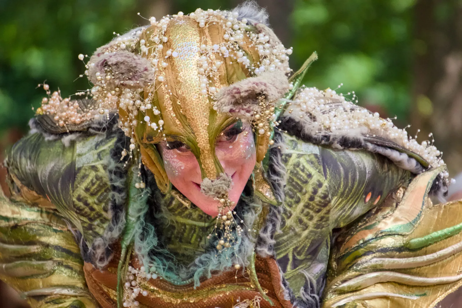 A performer in a golden fantasy creature costume