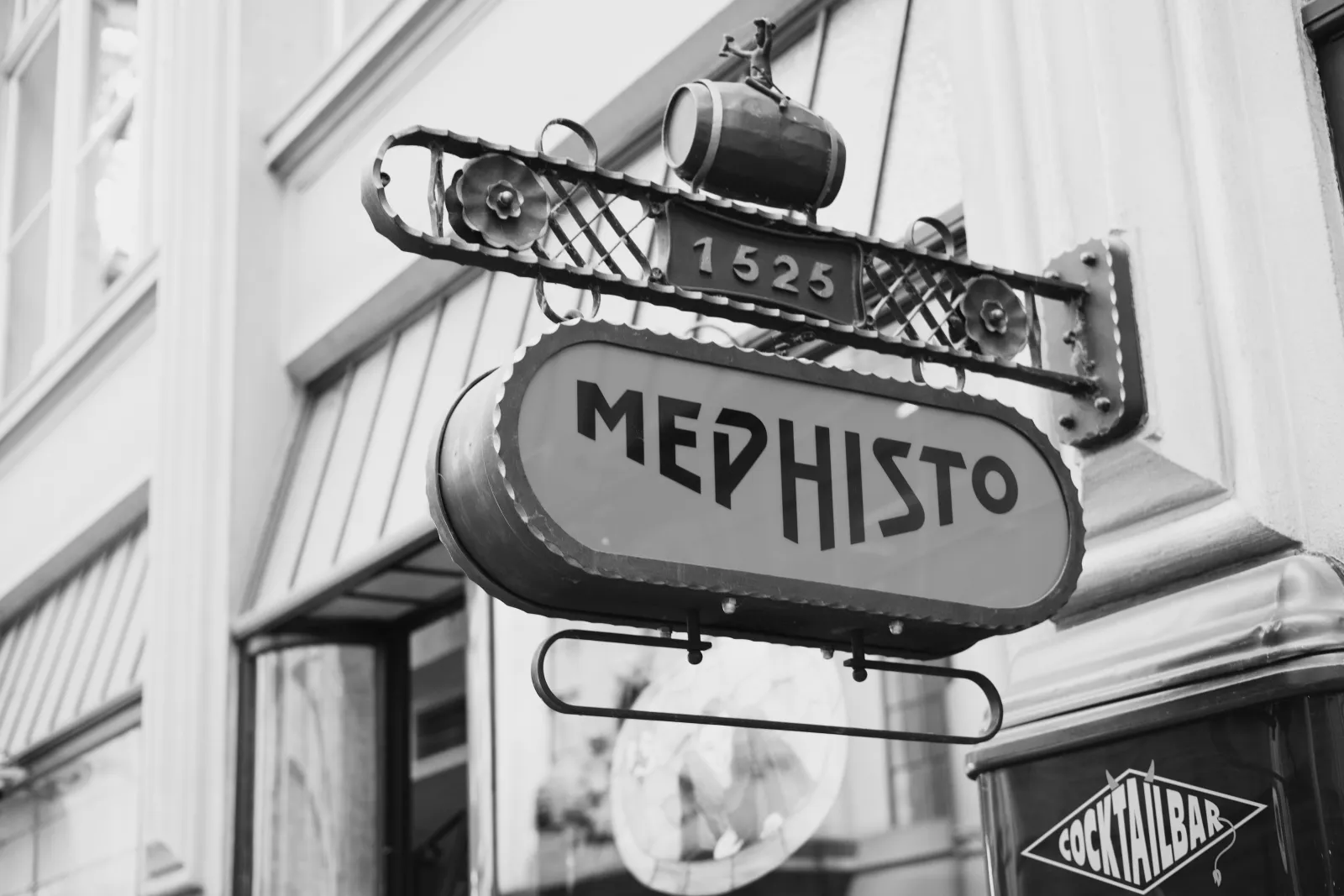 Black and white photo of the Mephisto sign at a cocktail bar