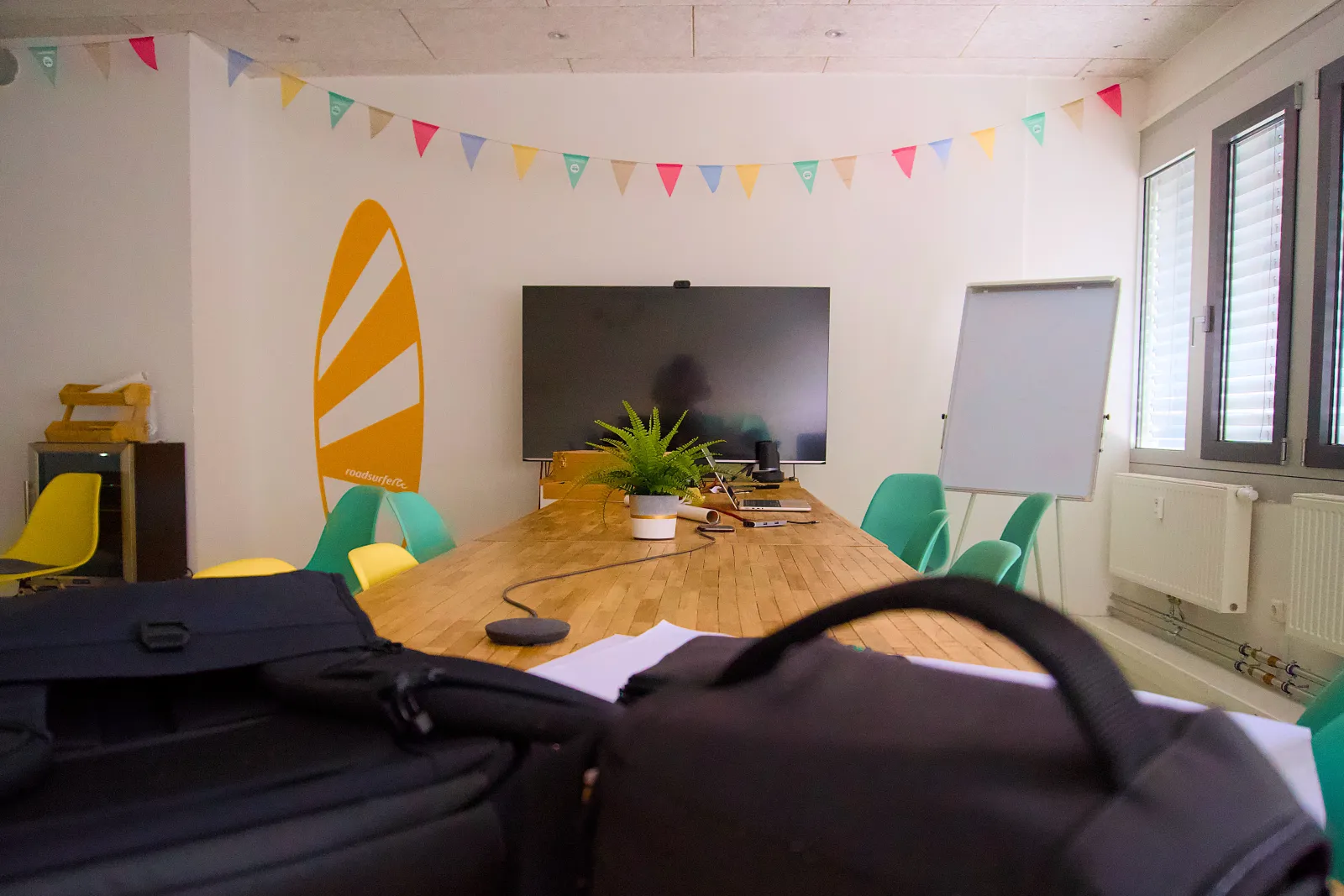 Meeting room at roadsurfer HQ with a surfboard wall graphic and bunting