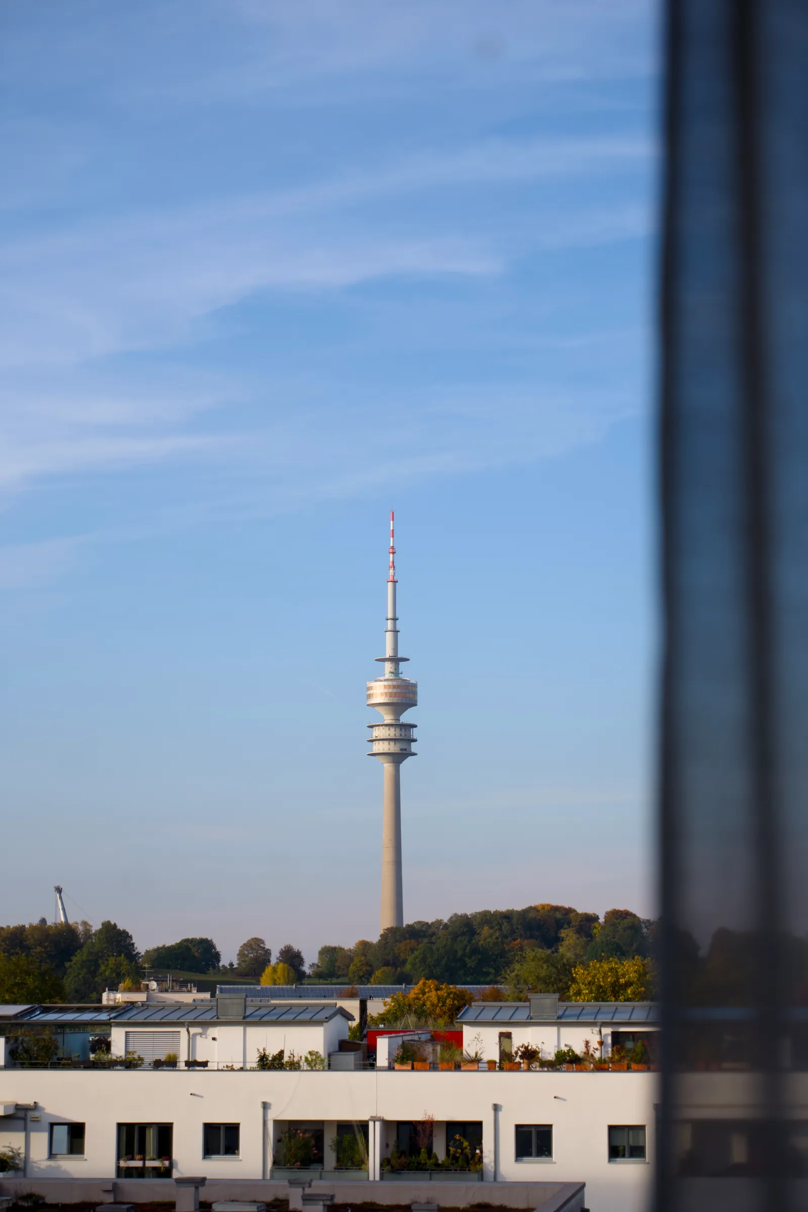 Olympic Tower in Munich above white rooftops