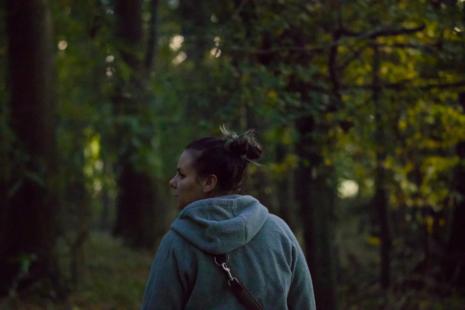 Nadine in a fleece hoodie in the forest at dusk
