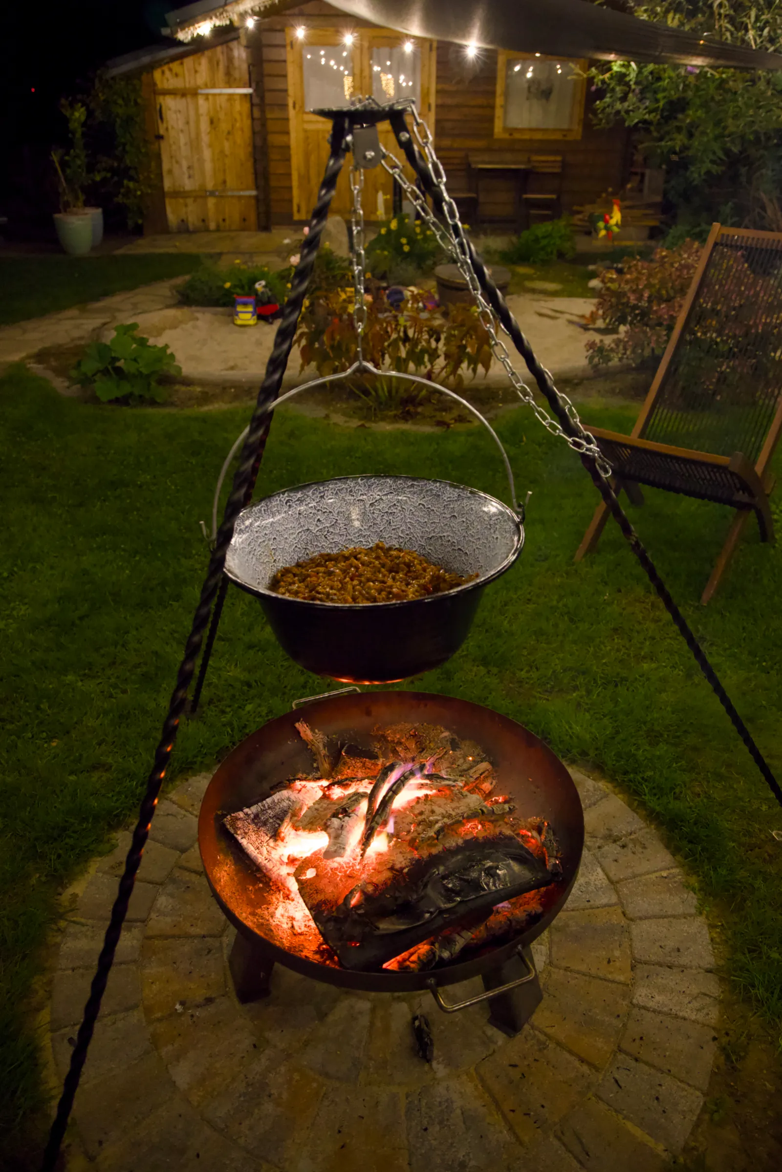 Goulash in a kettle over a fire bowl at night