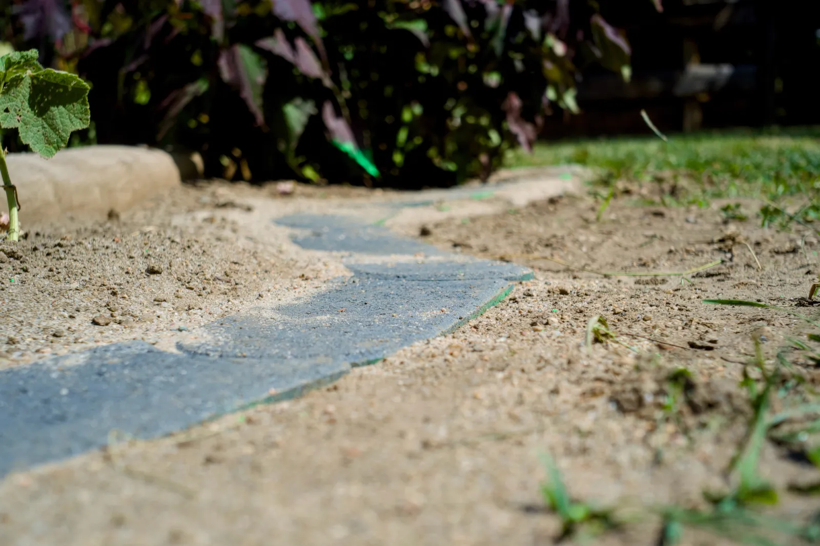 Slab edging between sand and planting bed