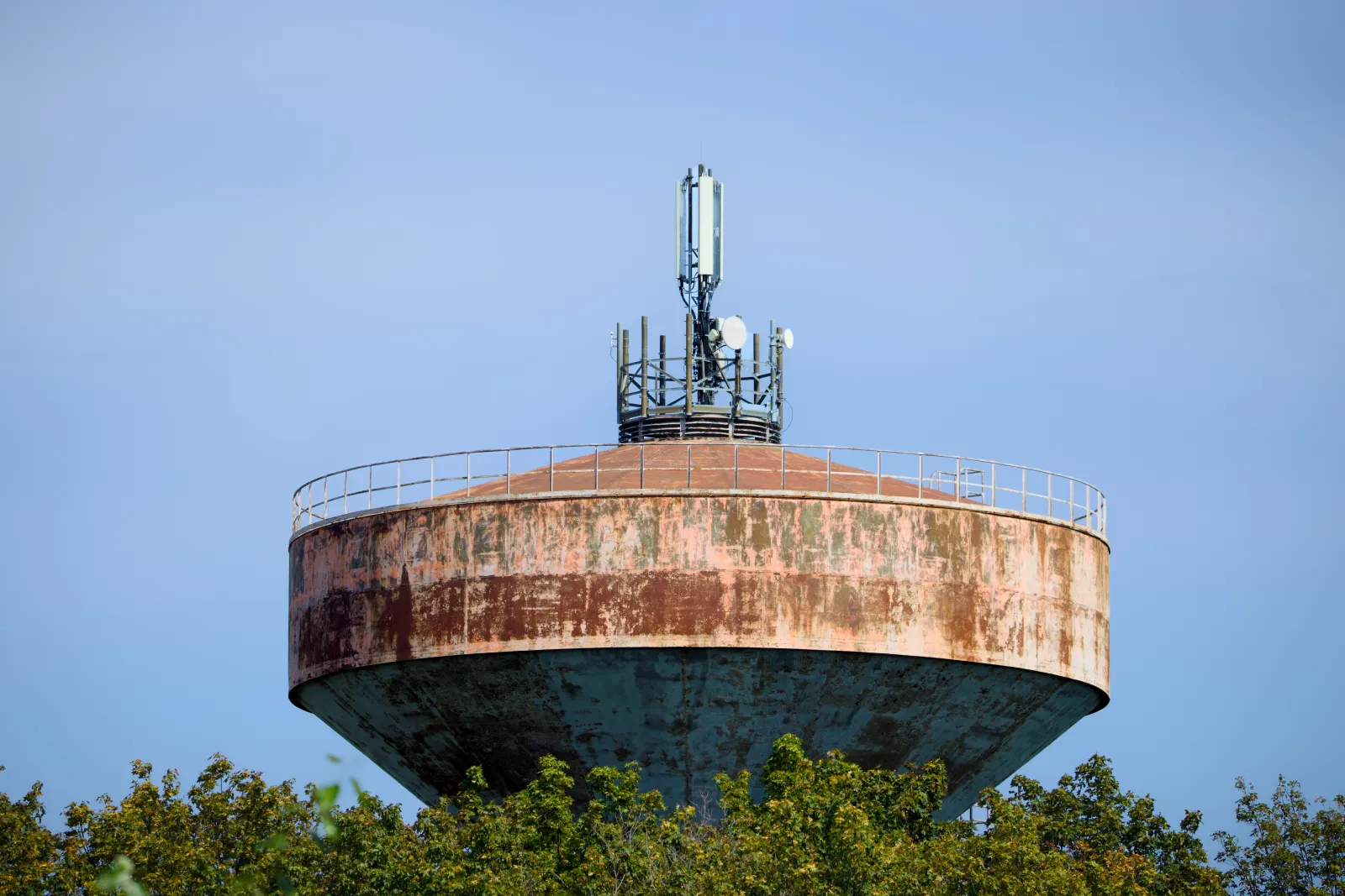 Weathered concrete water tower with mobile antennas on top