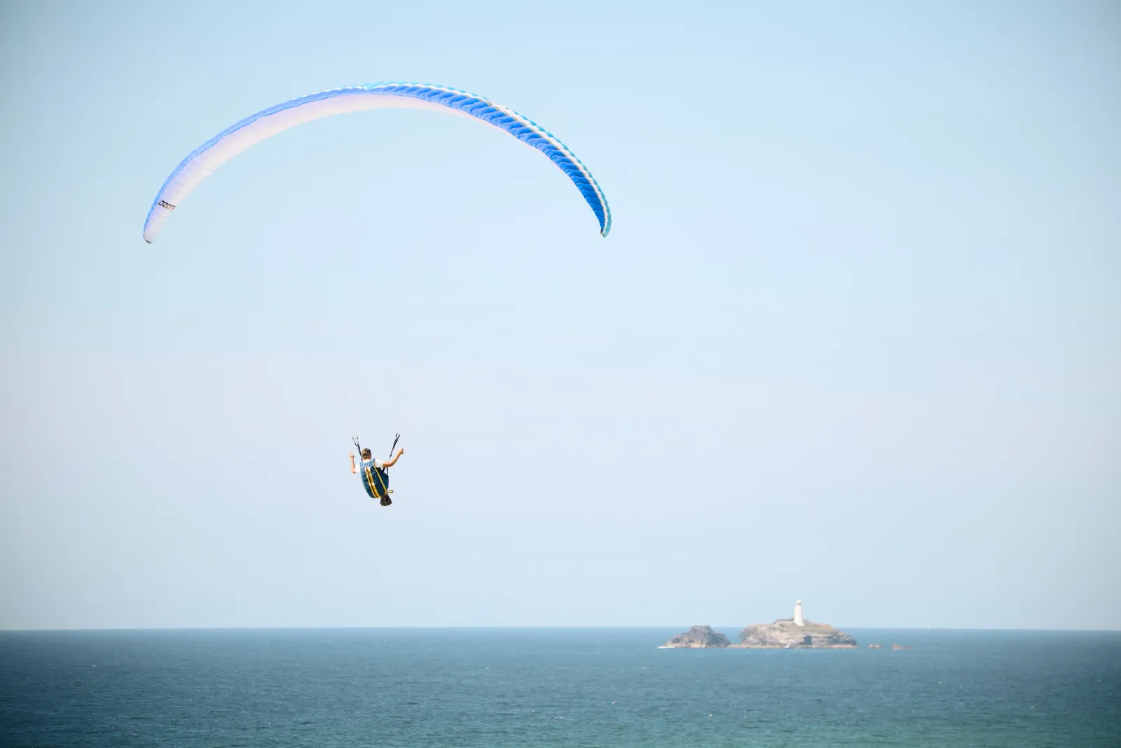 Paraglider over the sea, Godrevy lighthouse in the distance