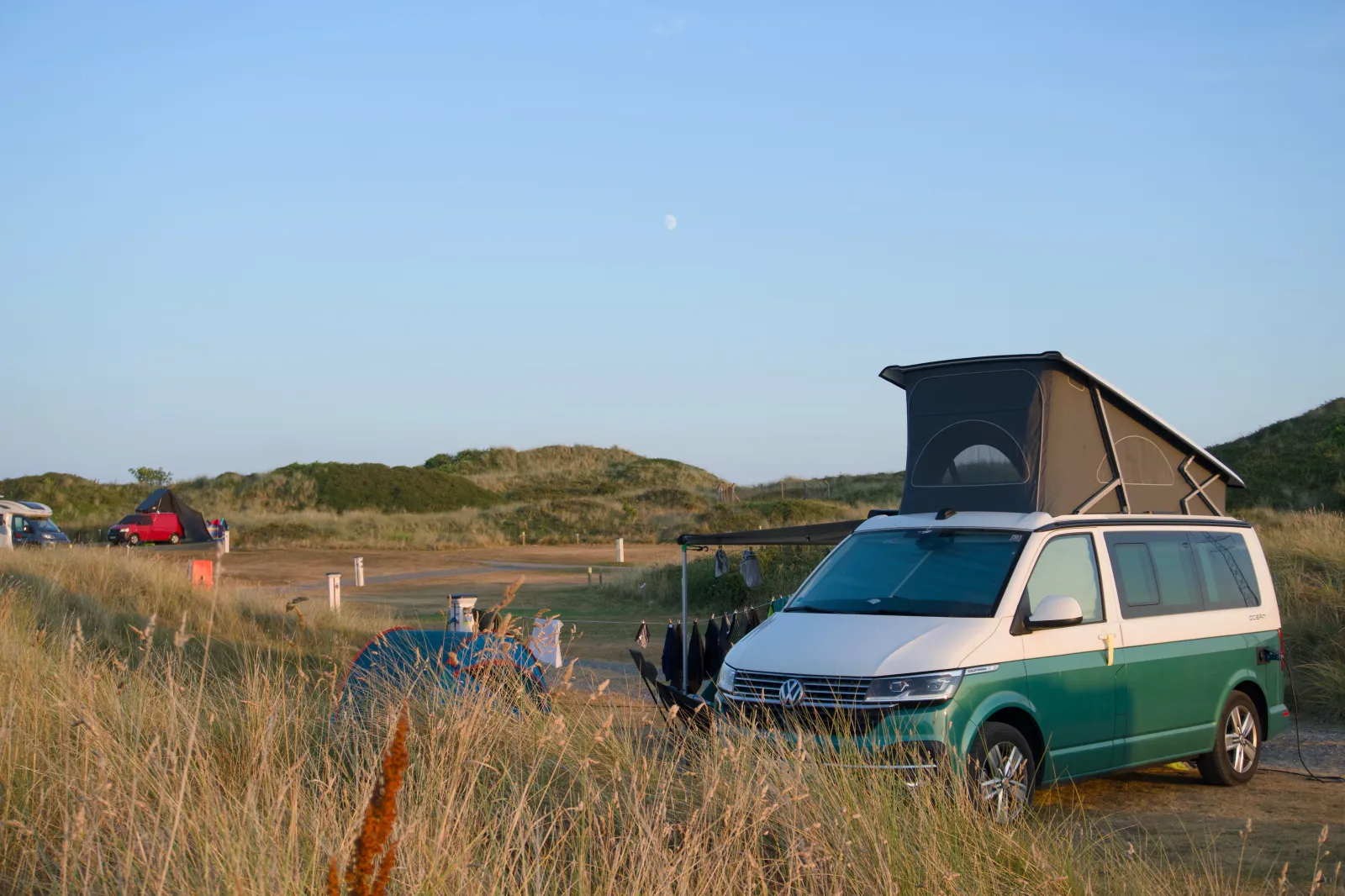 The California with the roof up on the pitch between the dunes, the moon above