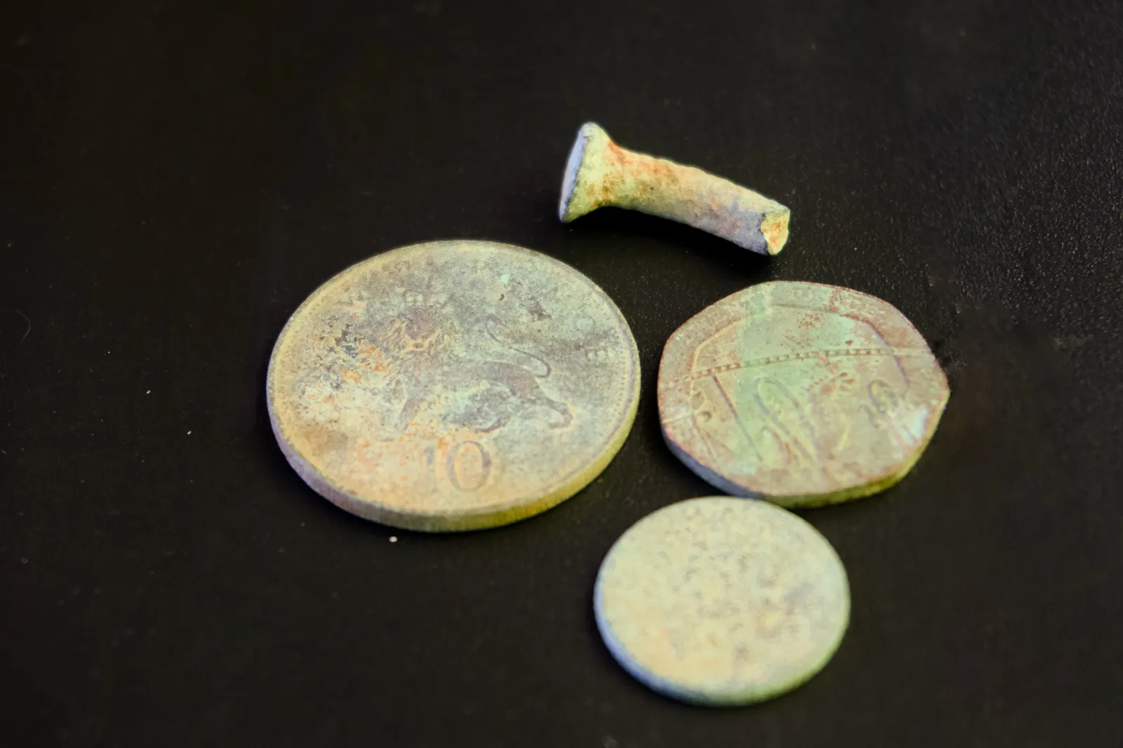 Corroded coins and an old nail
