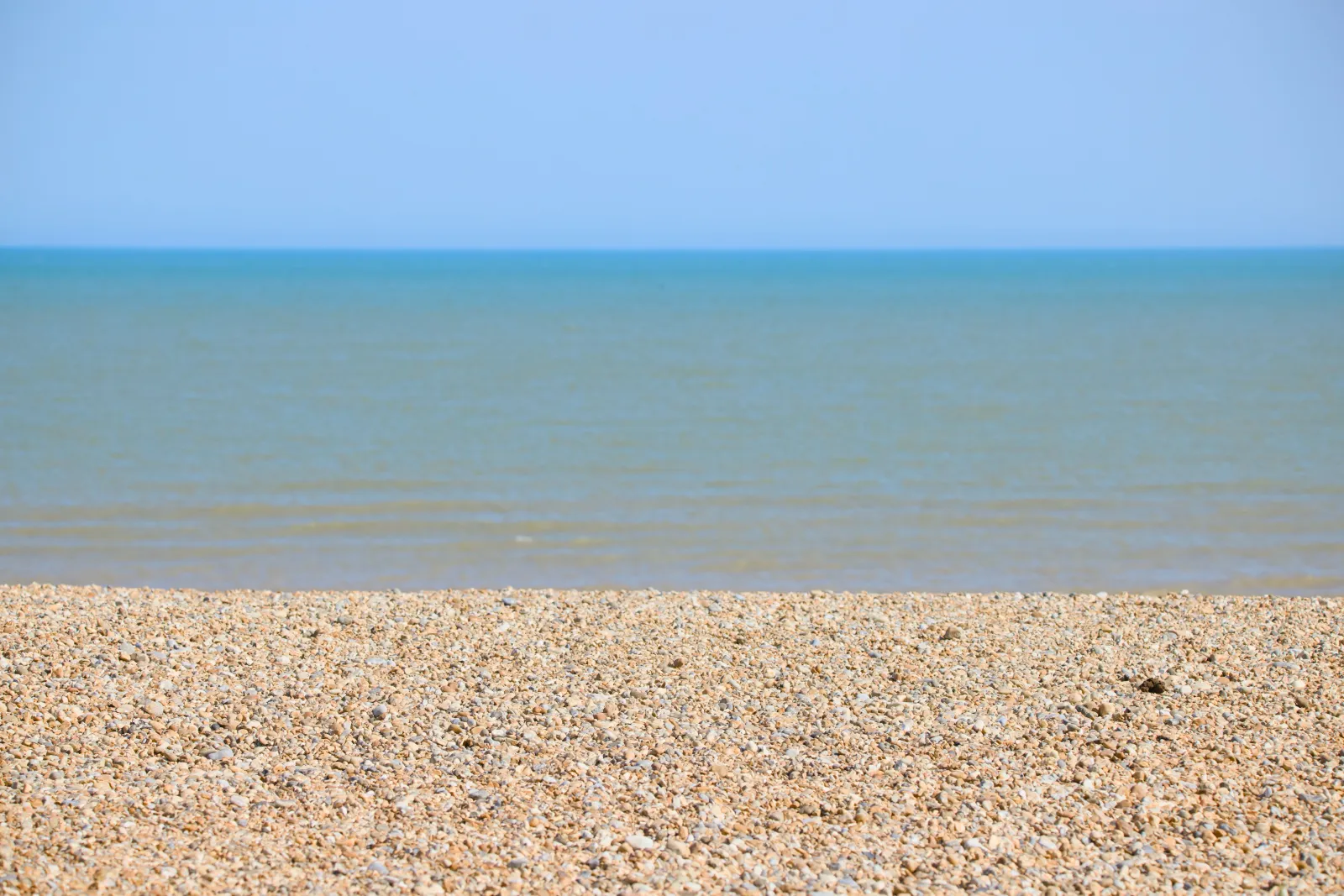 Shingle beach and the sea under a clear sky