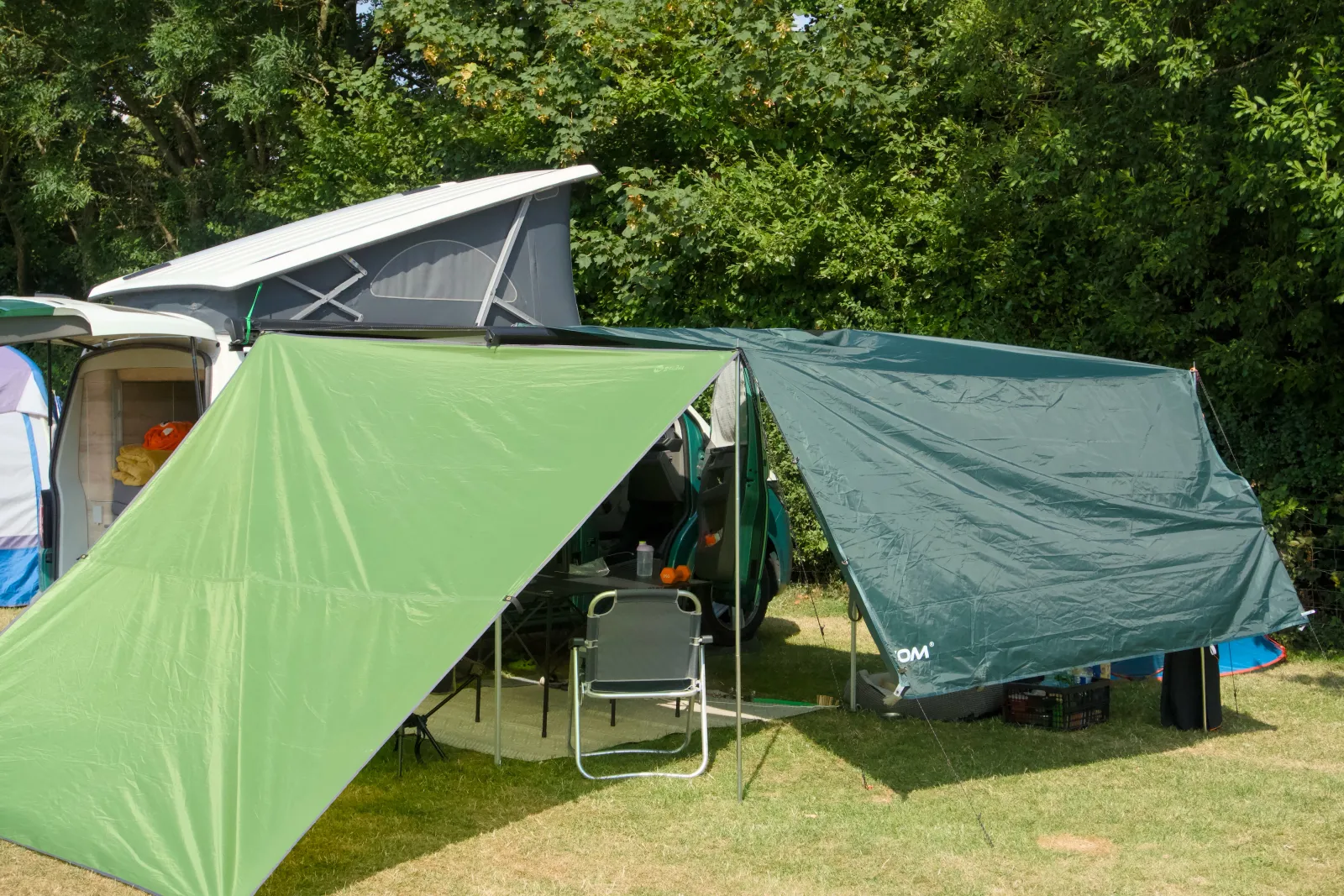 California with the roof up and a tarp shelter built next to it, pop-up tent behind
