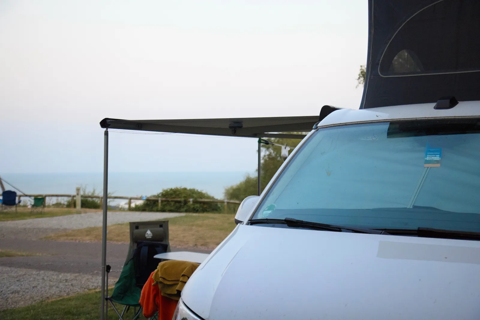 California with the roof up and the awning out, the sea in the background