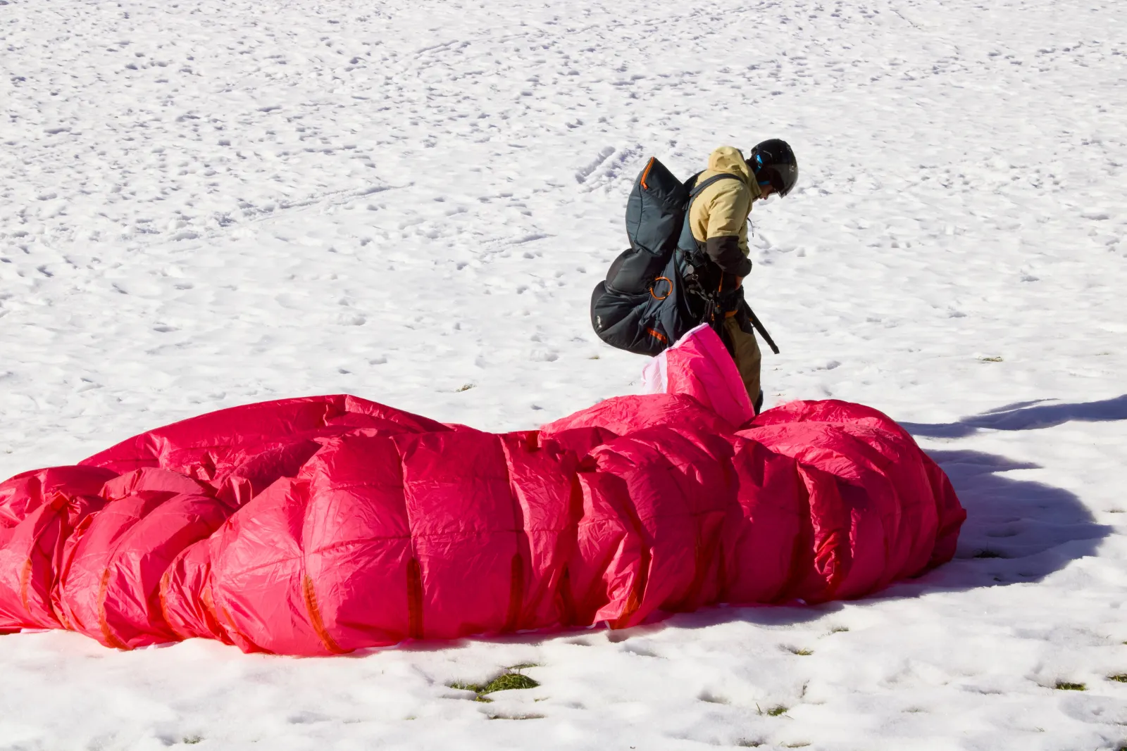 Tandem paraglider touching down in the snow