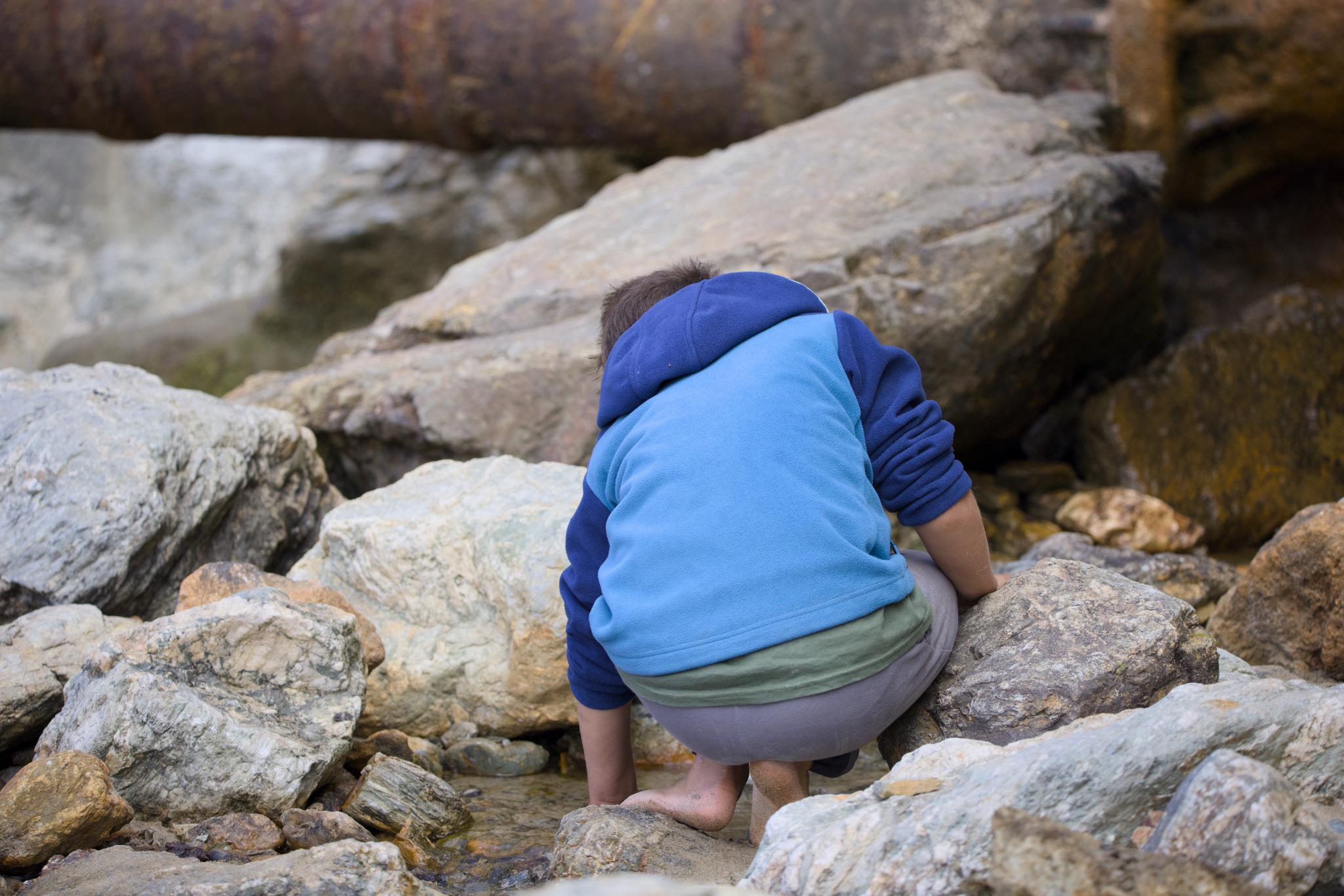 Tilian searching for coins between the rocks