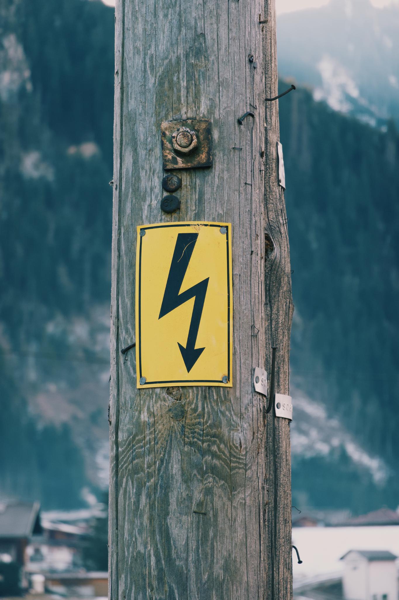 Old power pole with a warning sign