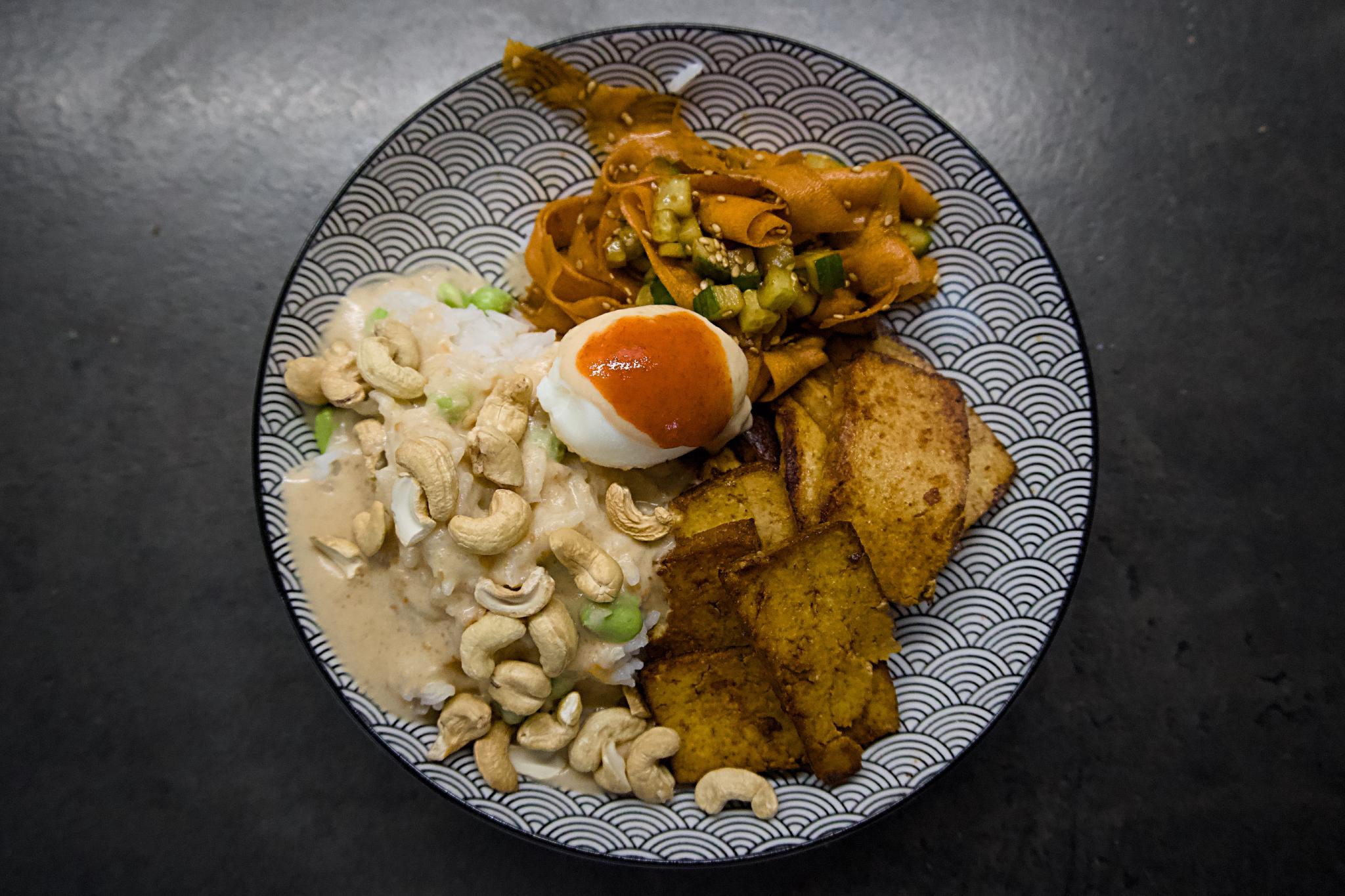 Asian-style bowl with rice, cashew sauce, half-boiled egg, pickled carrot ribbons and tofu