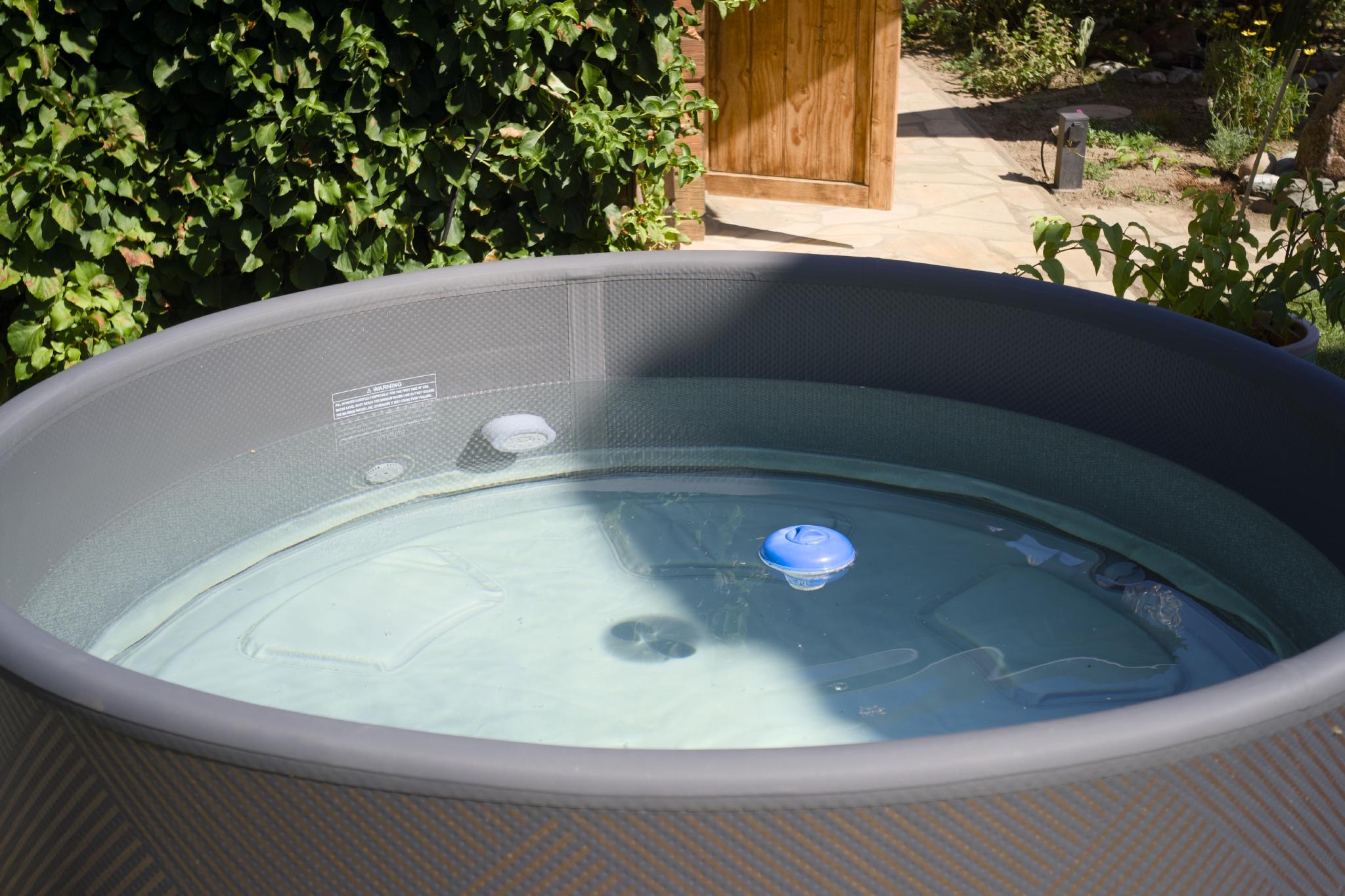 Gray inflatable whirlpool filled with water in a garden
