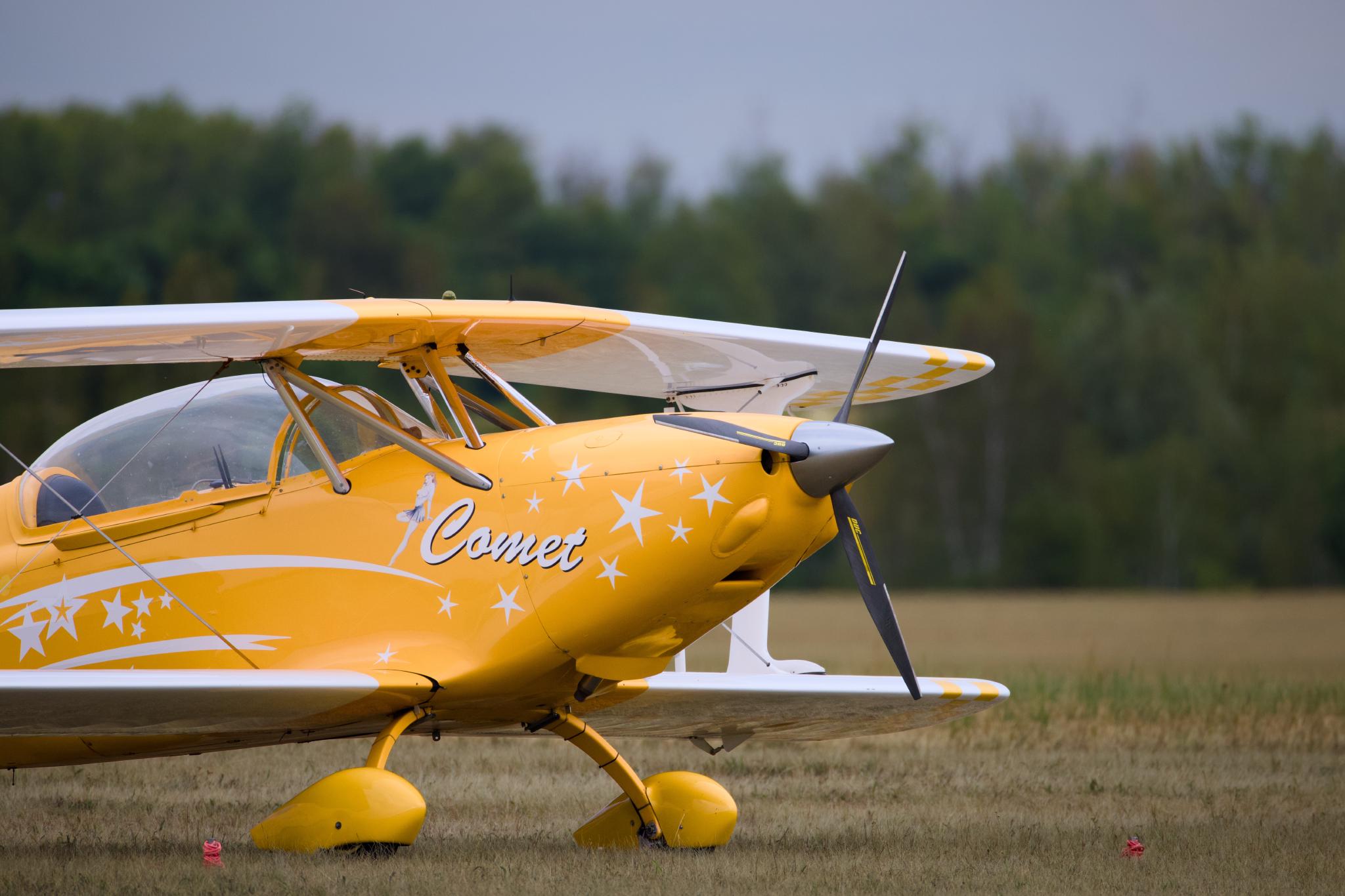 Yellow aerobatic biplane named Comet