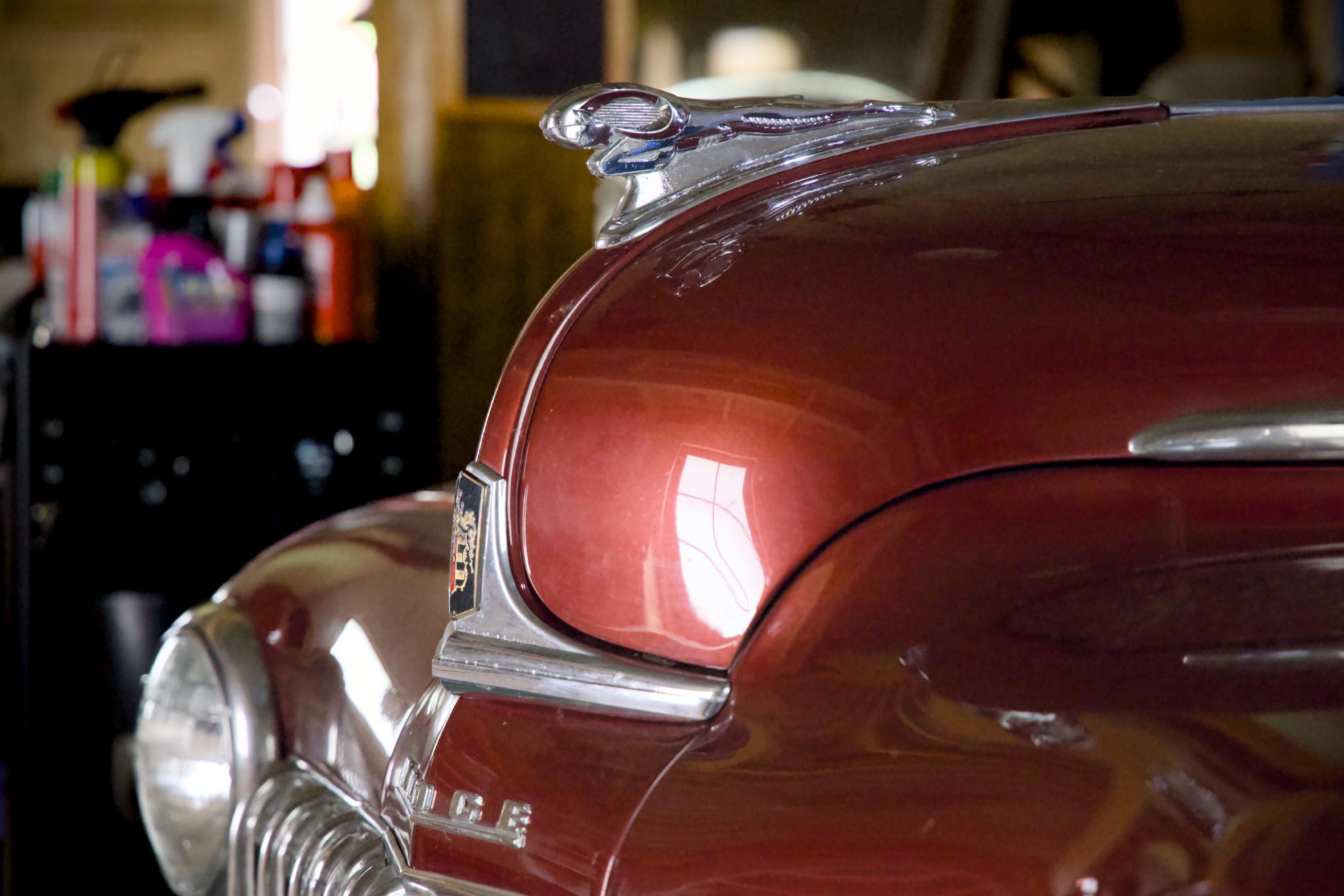 Hood ornament and grille of a maroon 1948 Dodge Coupe