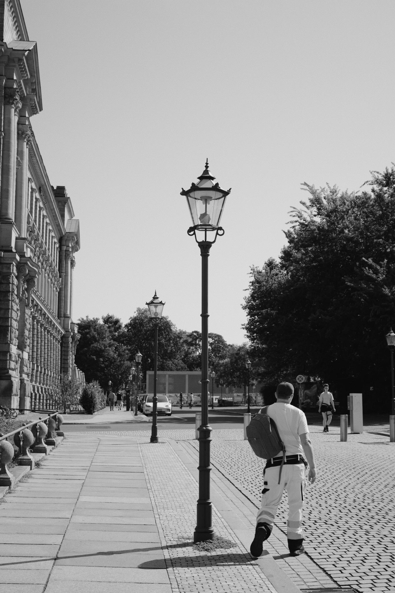 Black and white photo of a cast-iron street lamp in front of the Neues Rathaus