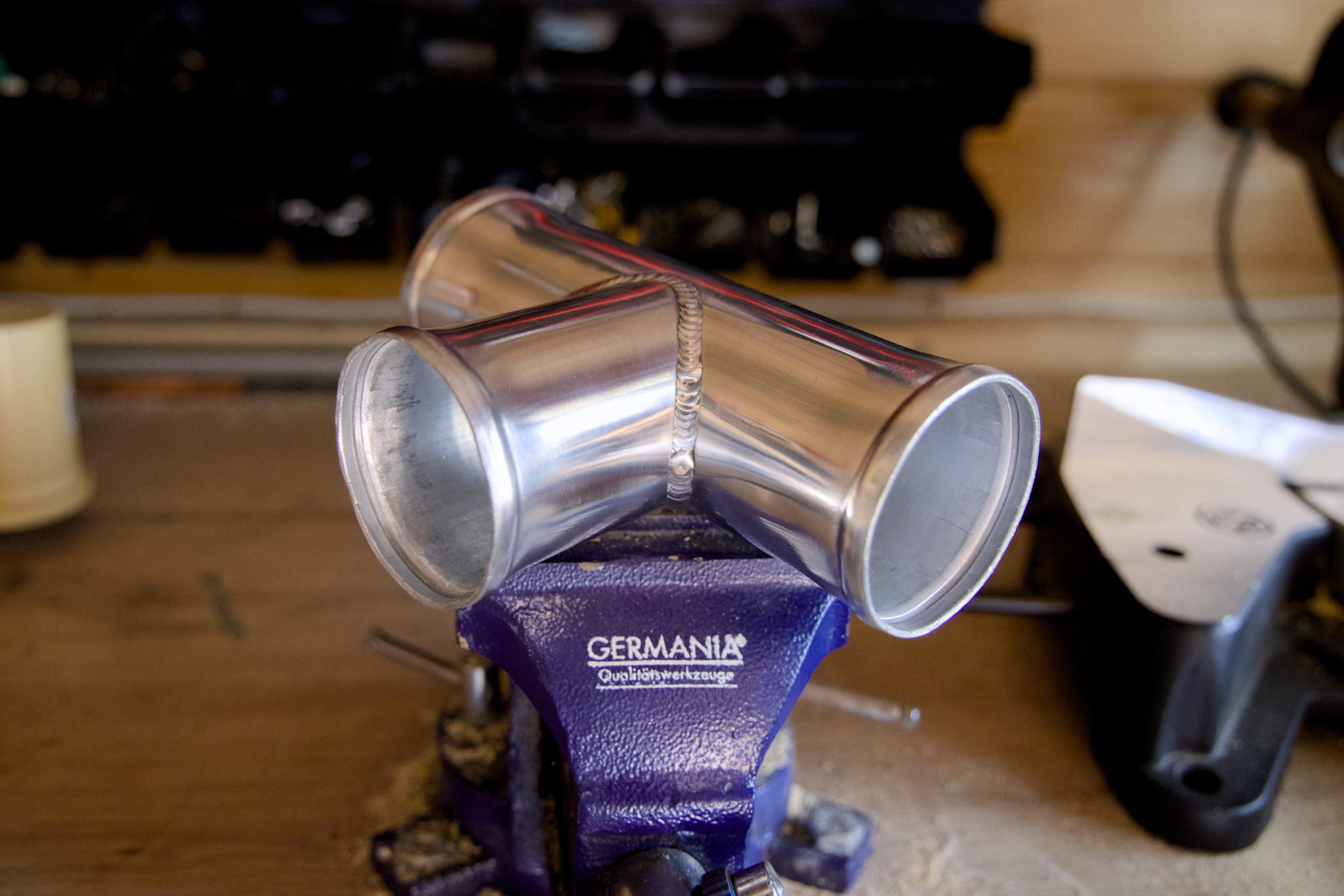 Welded aluminium T-piece clamped in a bench vise