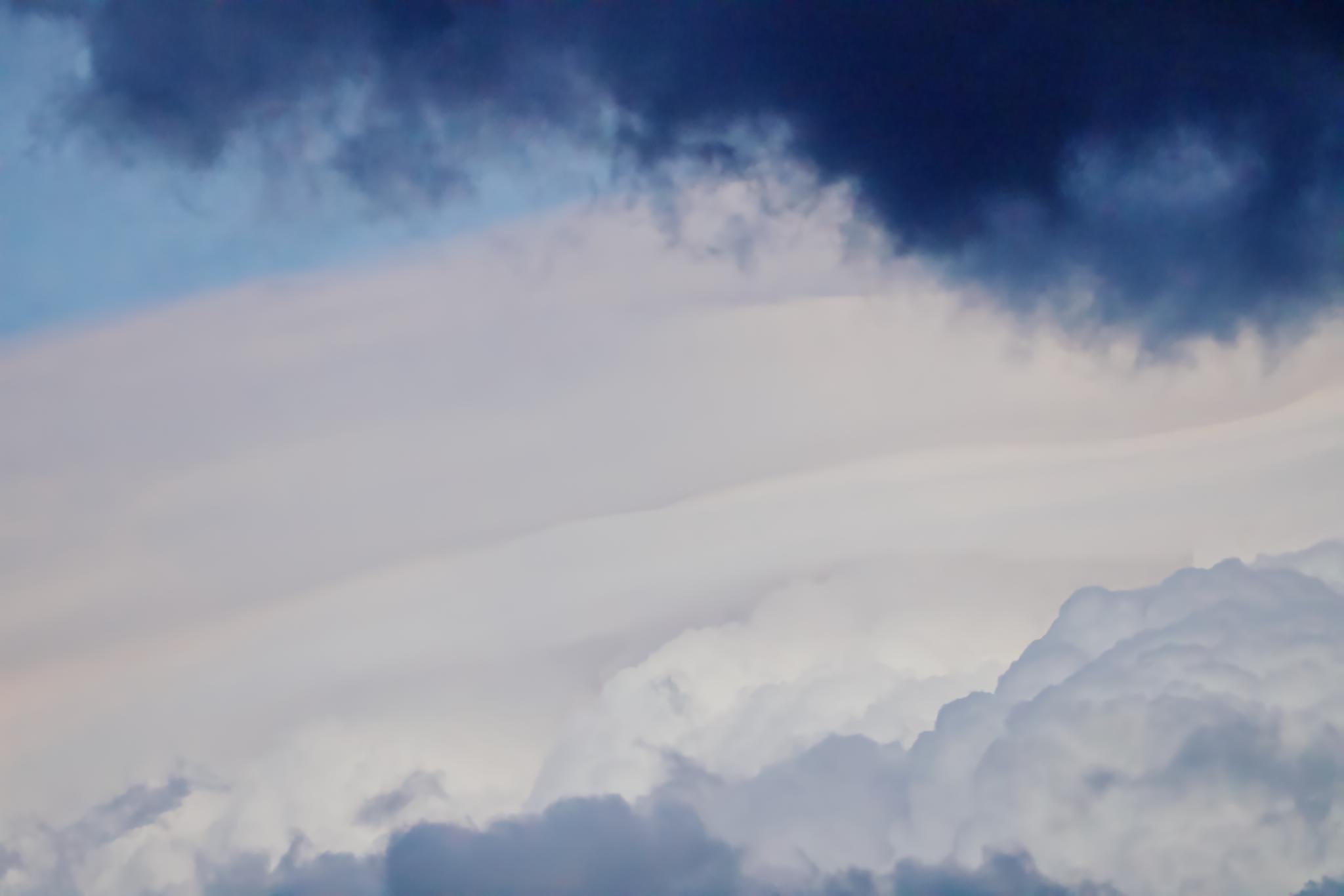 Dark cloud band over layered clouds