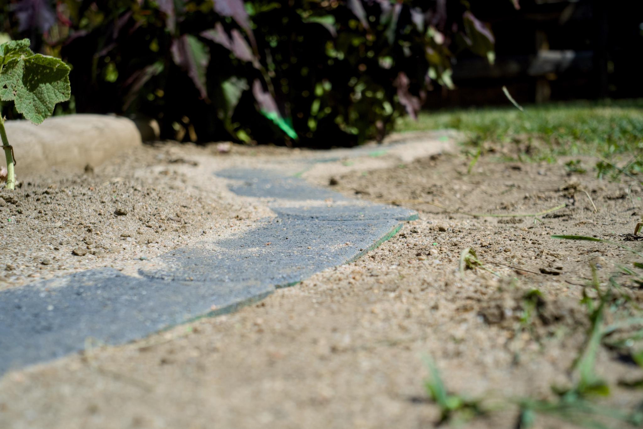 Slab edging between sand and planting bed